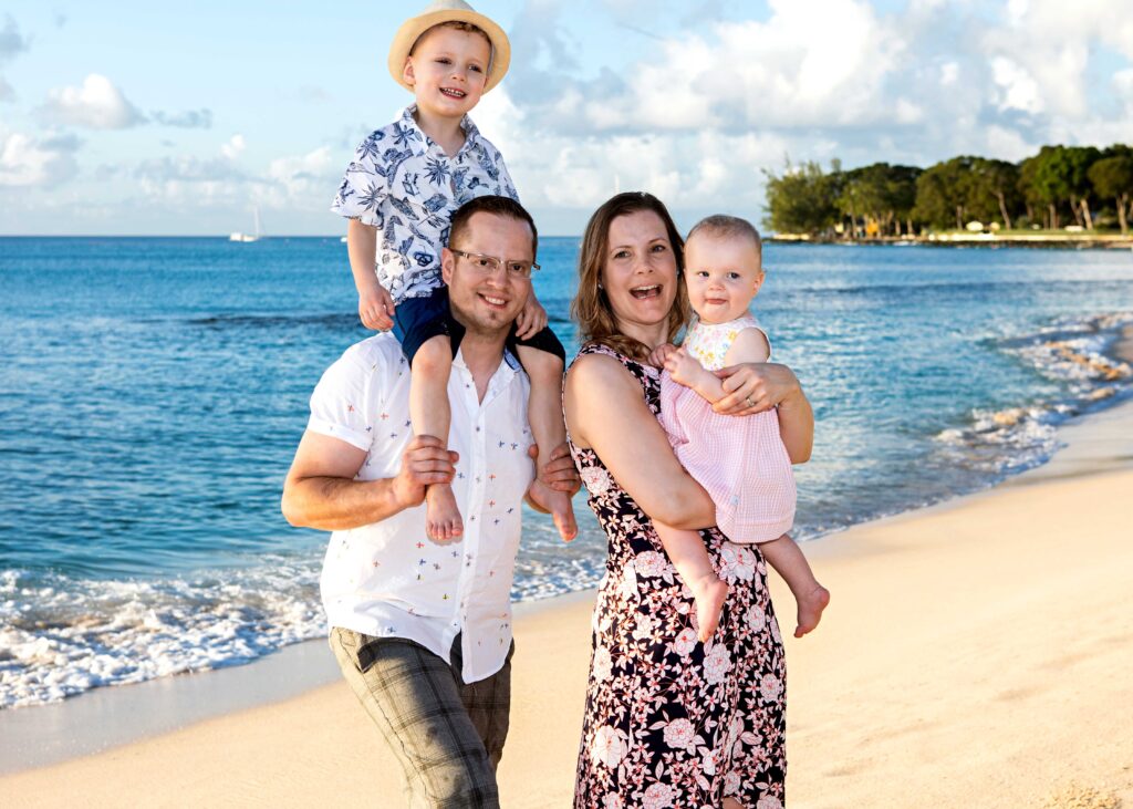 Family of four enjoying a Barbados beach portrait session