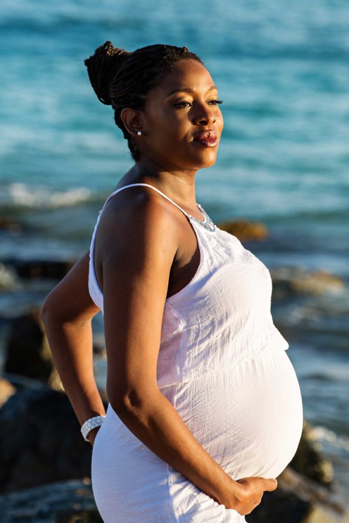 Expectant mother posing by the sea during a Barbados maternity session
