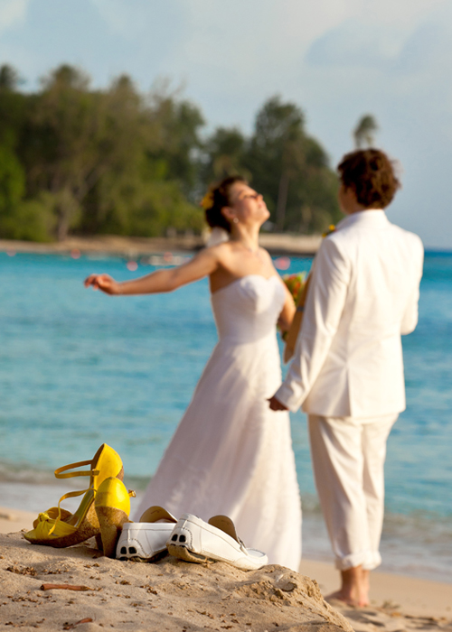 Newlyweds enjoying the sea barefoot after their Barbados beach wedding