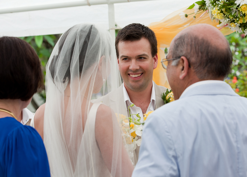 Groom smiling at the bride during their outdoor wedding ceremony