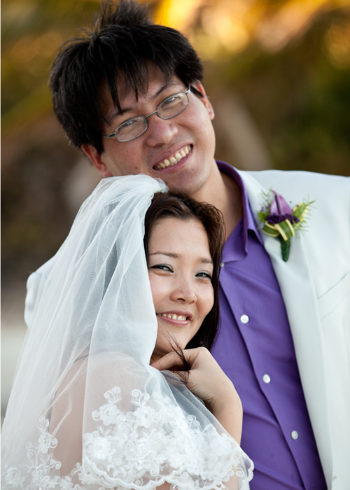 Smiling newlyweds posing together after their Barbados beach wedding