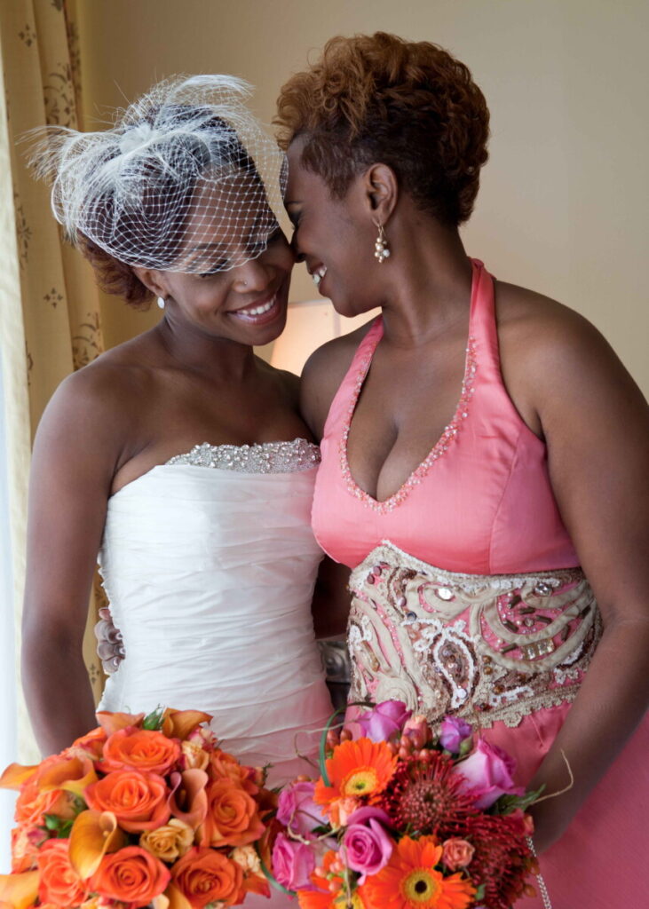 Bride sharing a warm moment with a loved one while holding colorful bouquets