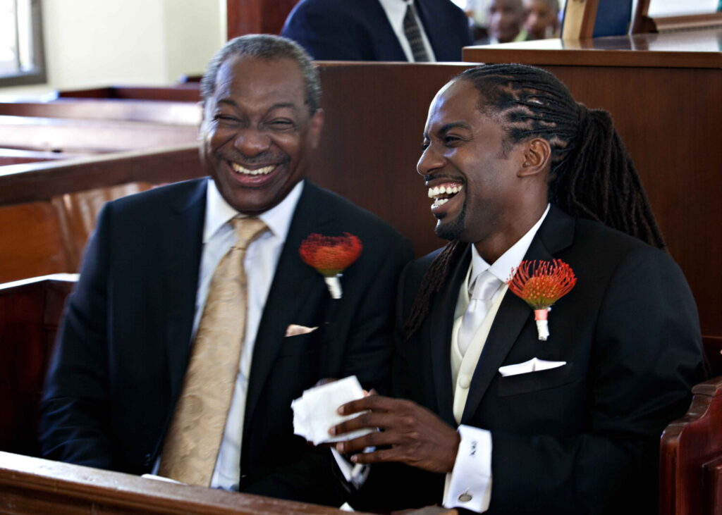 Groom laughing with a loved one during the church wedding ceremony