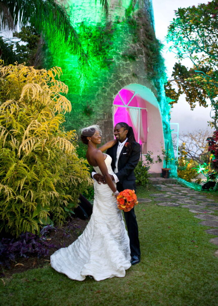 Newlyweds embracing in a colorful tropical garden after their wedding