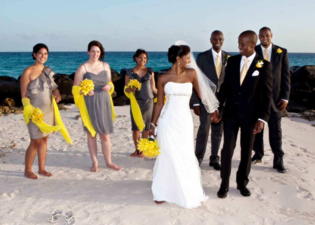 Wedding party walking barefoot together on a Barbados beach